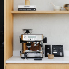 A steel Sage Barista Pro espresso machine featuring a built-in grinder, LCD display, steam wand, and a free 3-month coffee subscription, ideal for making barista-quality coffee at home.